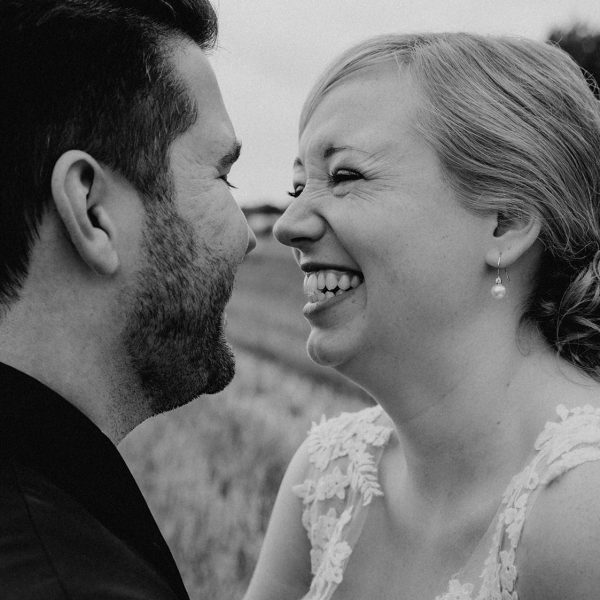 Braut lacht ihren Bräutigam an beim Fotoshooting auf einem Stoppelacker fotografiert von Hochzeitsfotograf Darmstadt