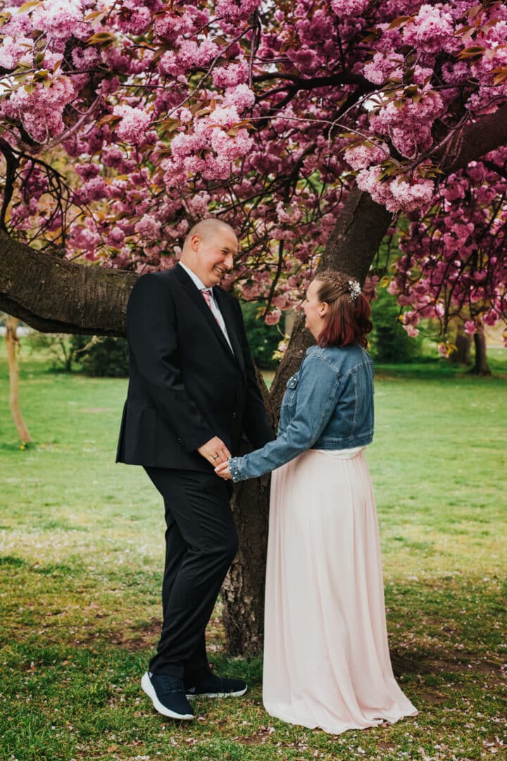 Brautpaar steht unter einem blühenden Kirschbaum im Herrngarten Darmstadt