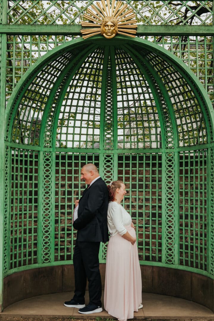 Mann und Frau halten ihre dicken Bäuche im Prinz-Georg-Garten Darmstadt