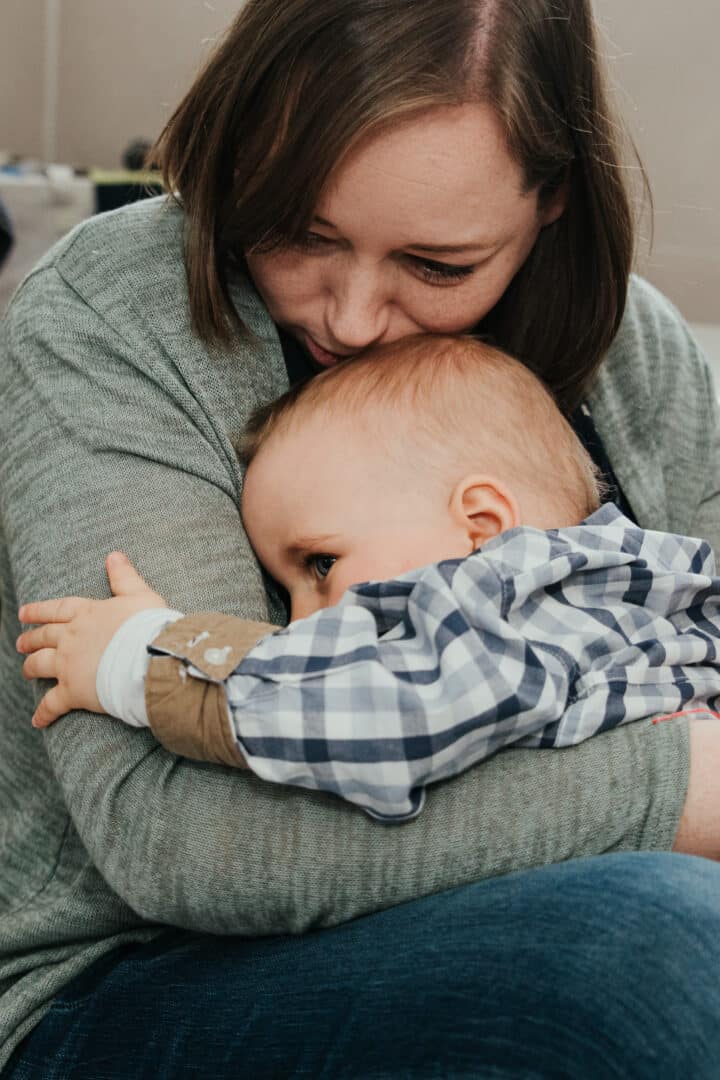 Eine Mutter hält ihren kleinen Jungen ganz fest im Arm und tröstet ihn.