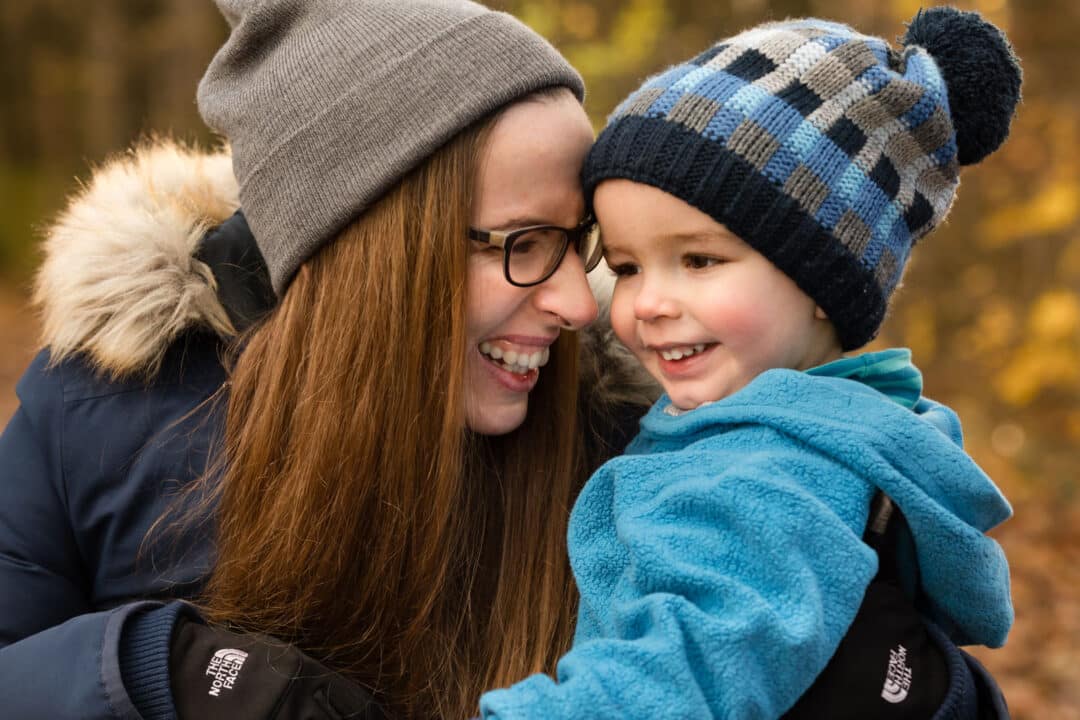 Mutter hält lachenden Sohn auf Arm bei einem herbstlichen Familienshooting in Darmstadt