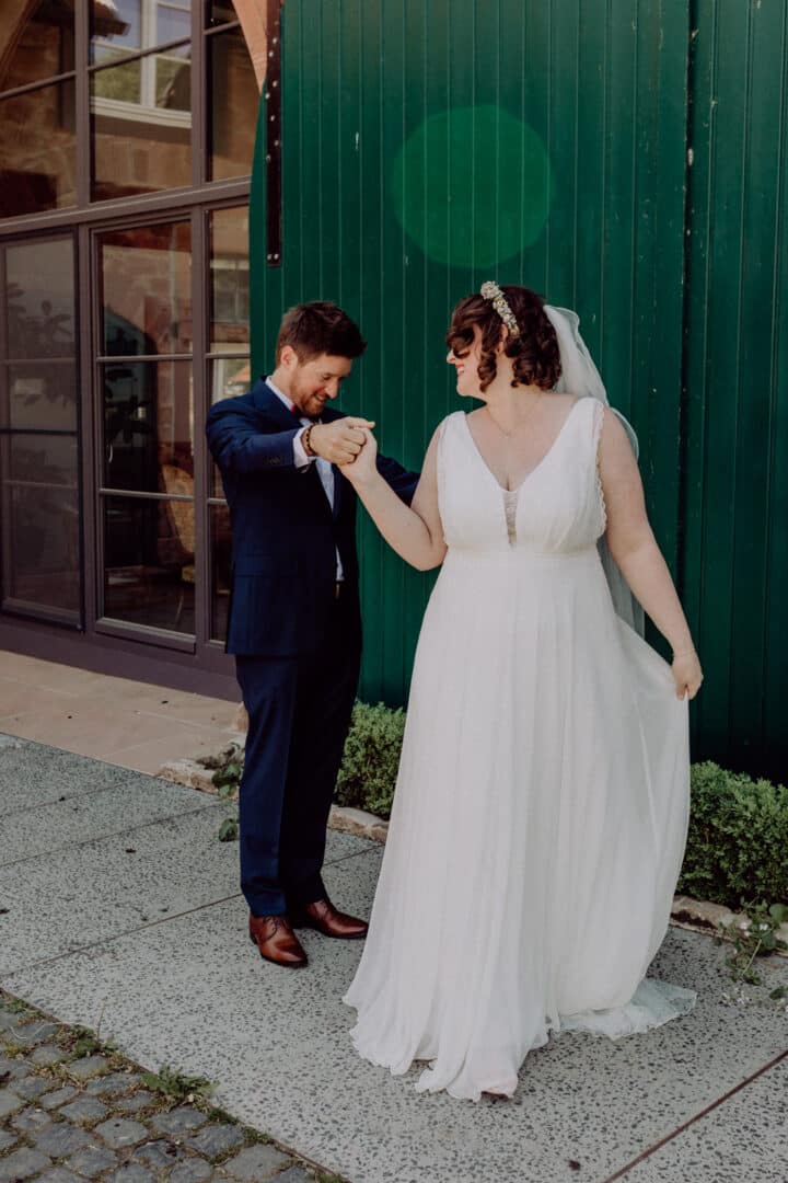 First Look und der Bräutigam schaut sich das Brautkleid seiner Frau an.