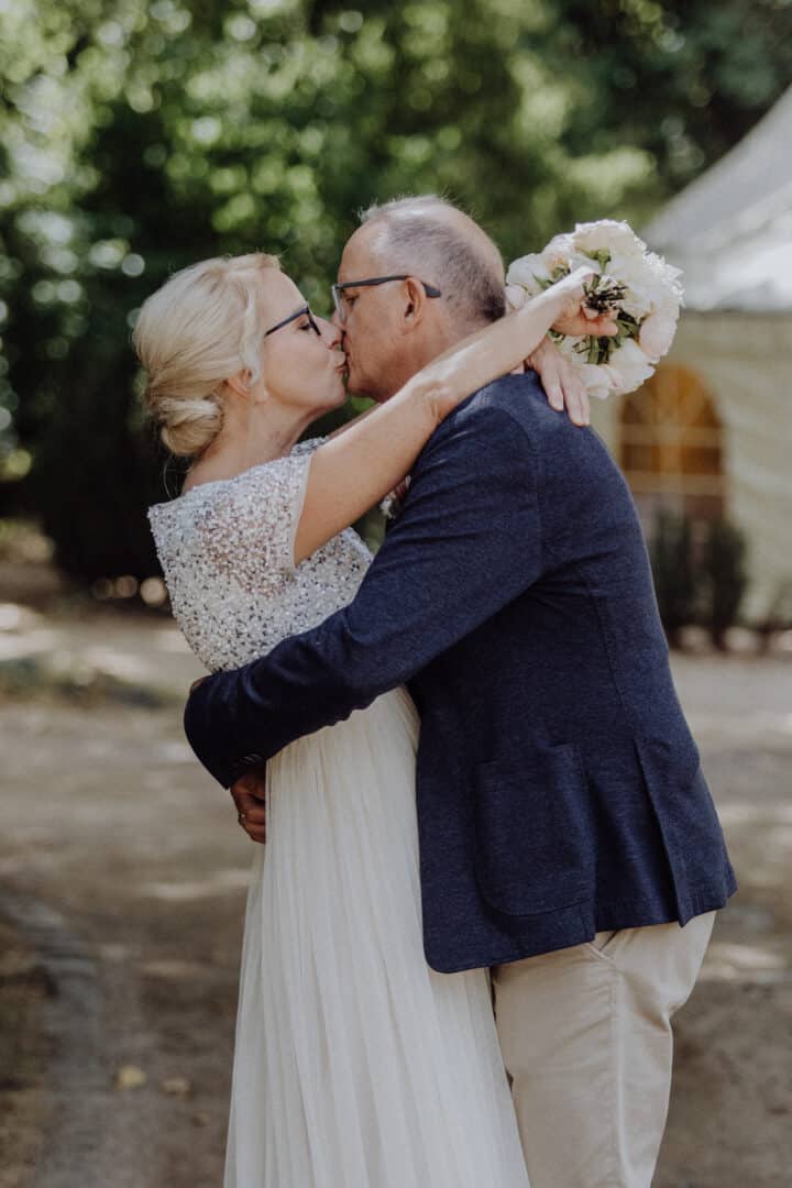 Braut küsst ihren Mann auf dem Hofgut Dippelshof im Mühltal