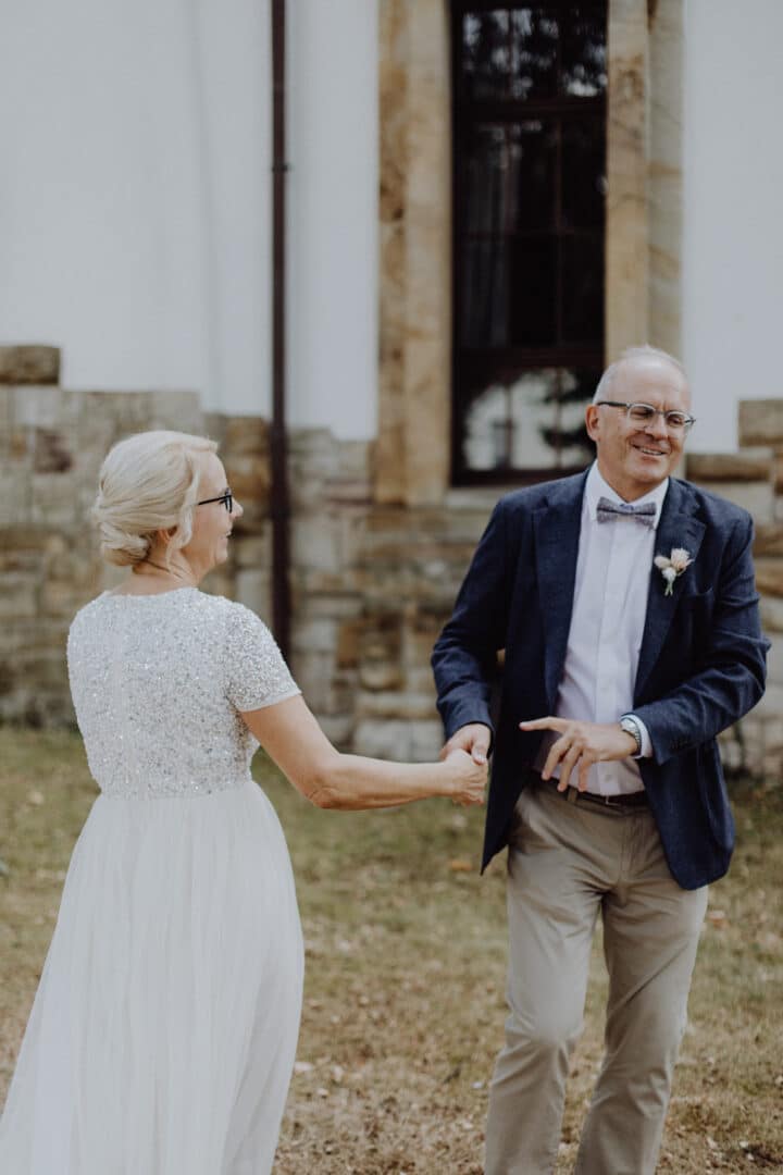 Brautpaar tanzt lachend auf einer Wiese auf dem Hofgut Dippelshof