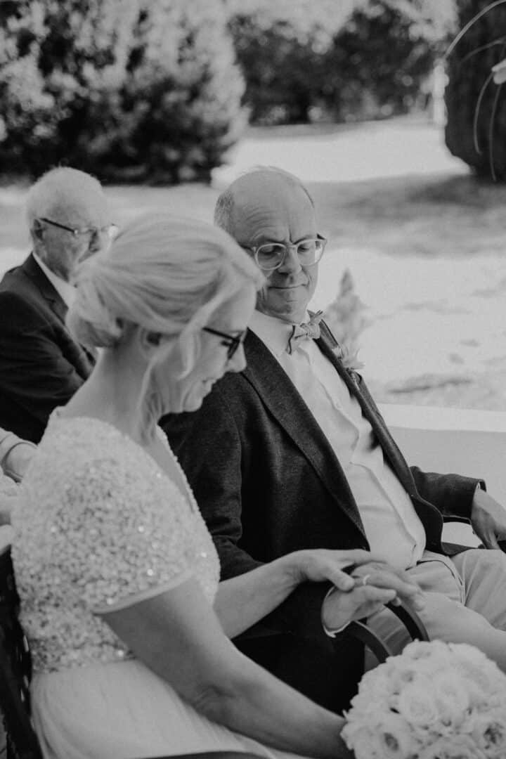 Braut schaut auf den Ring an der Hand ihres Mannes auf dem Hofgut Dippelshof