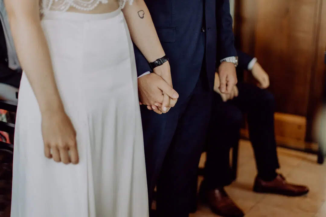 Braut und Bräutigam halten sich an der Hand