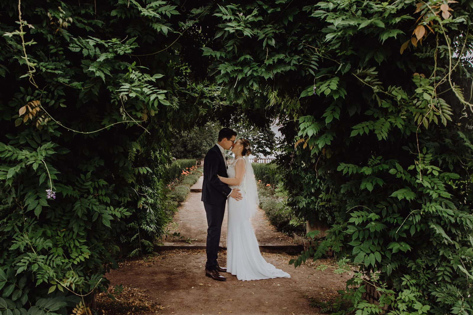 Brautpaar steht unter Pflanzenranken auf der rosenhoehe in darmstadt