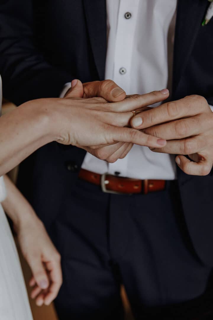 Bräutigam steckt seiner Braut den Ring an.