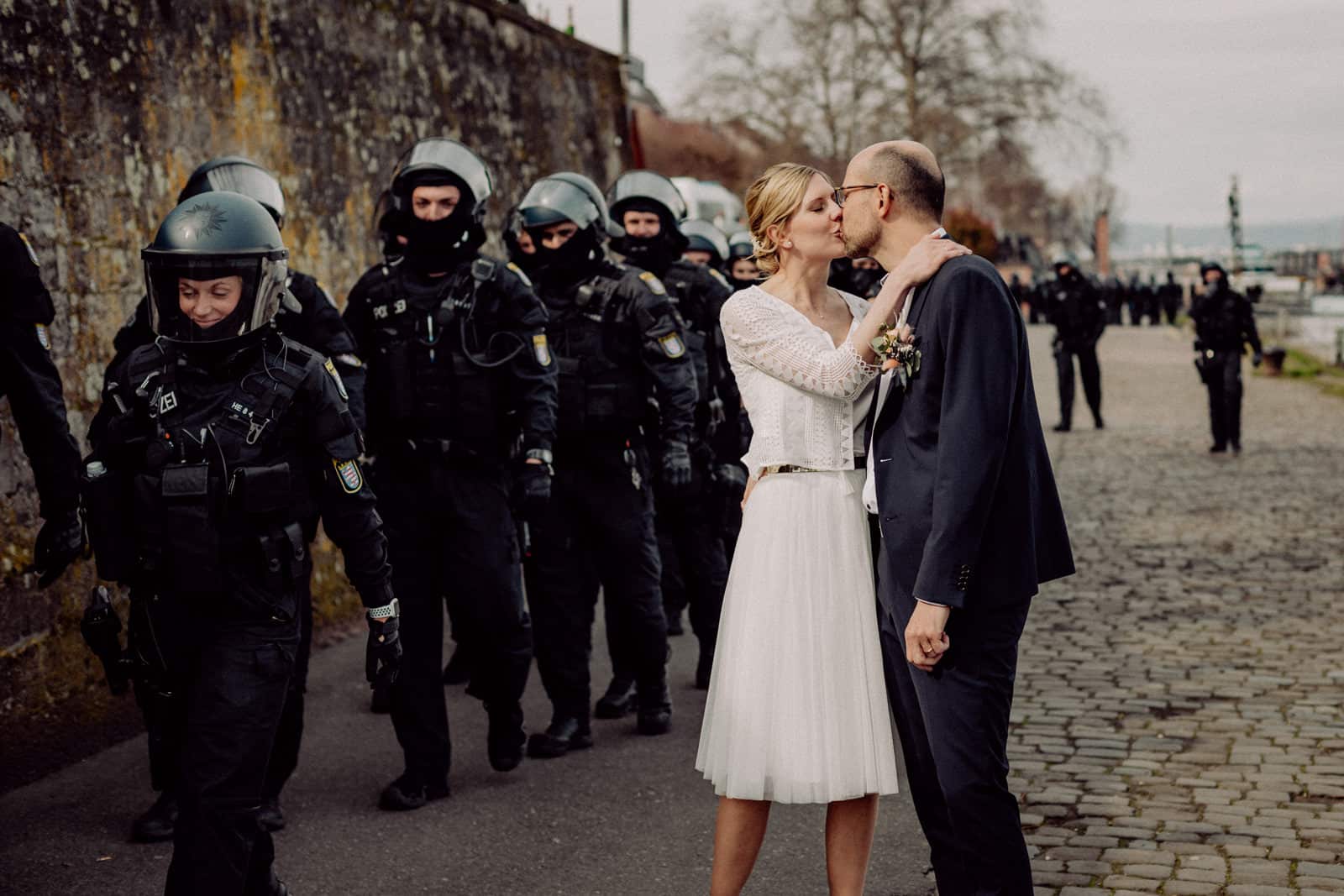 Brautpaar küsst sich und ist umgeben von Polizei in Mainz.