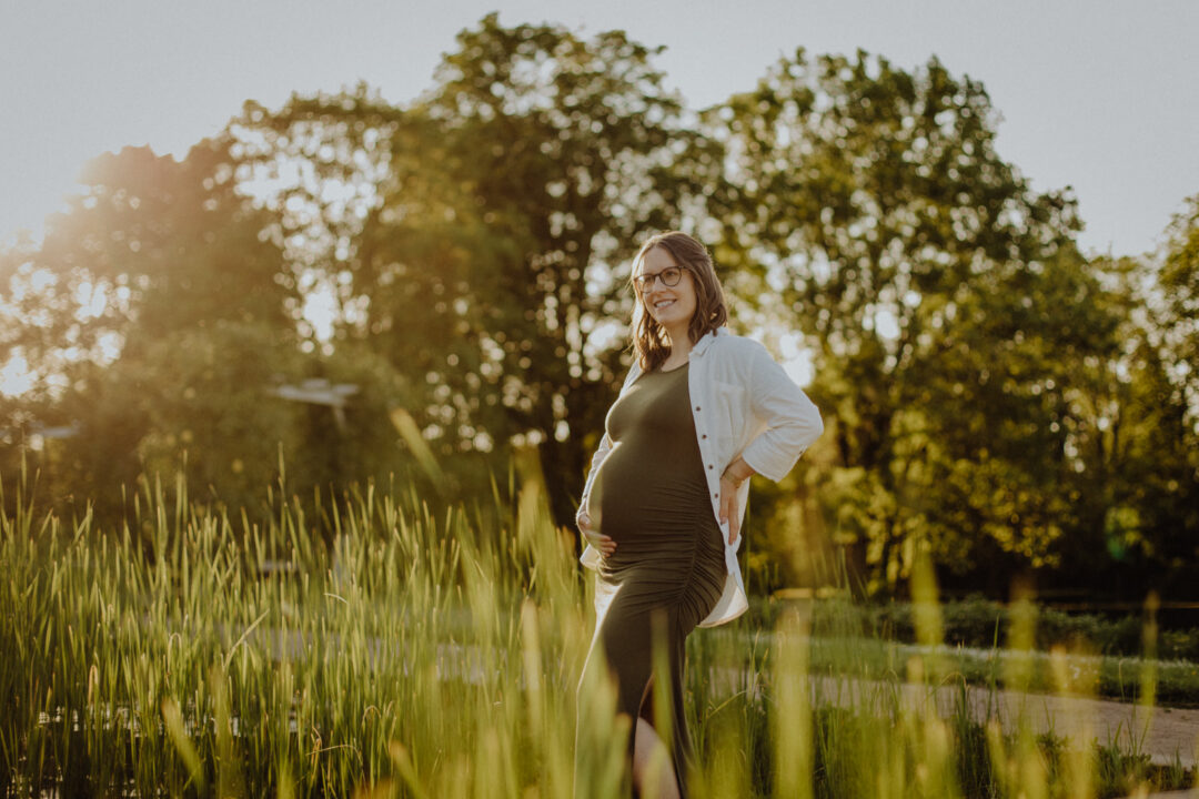 Eine schwangere Frau beim Babybauchshooting in der Natur von Darmstadt mit wunderschönem Sonnenuntergang.