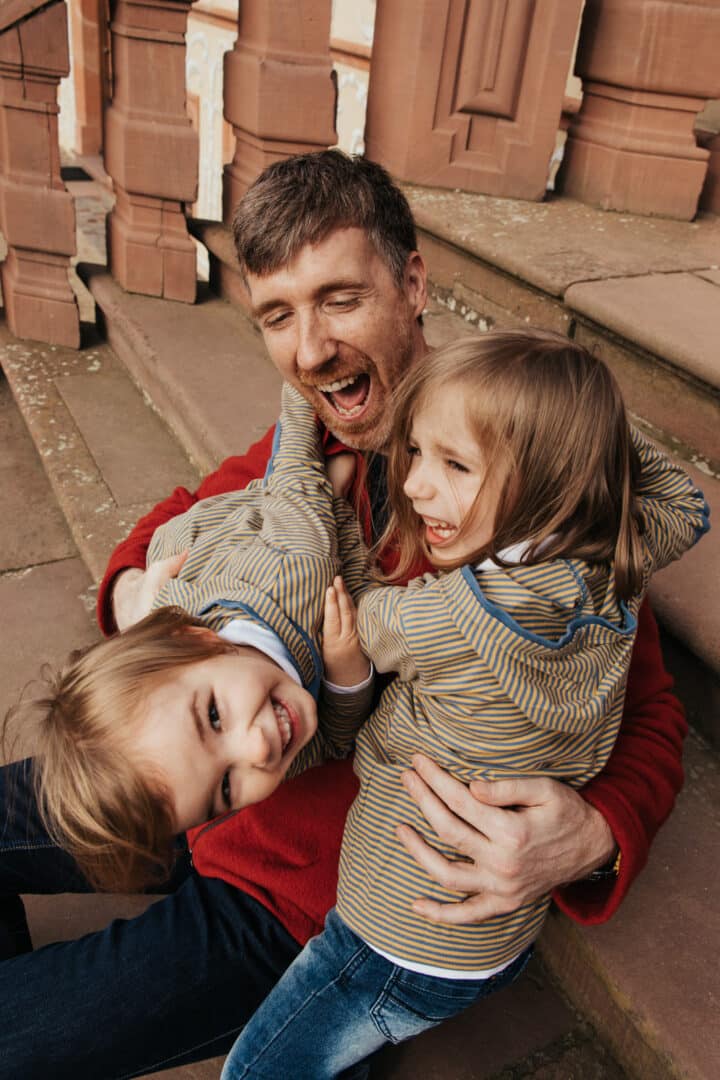 Ein Vater hält seine zwei Kinder im Arm
