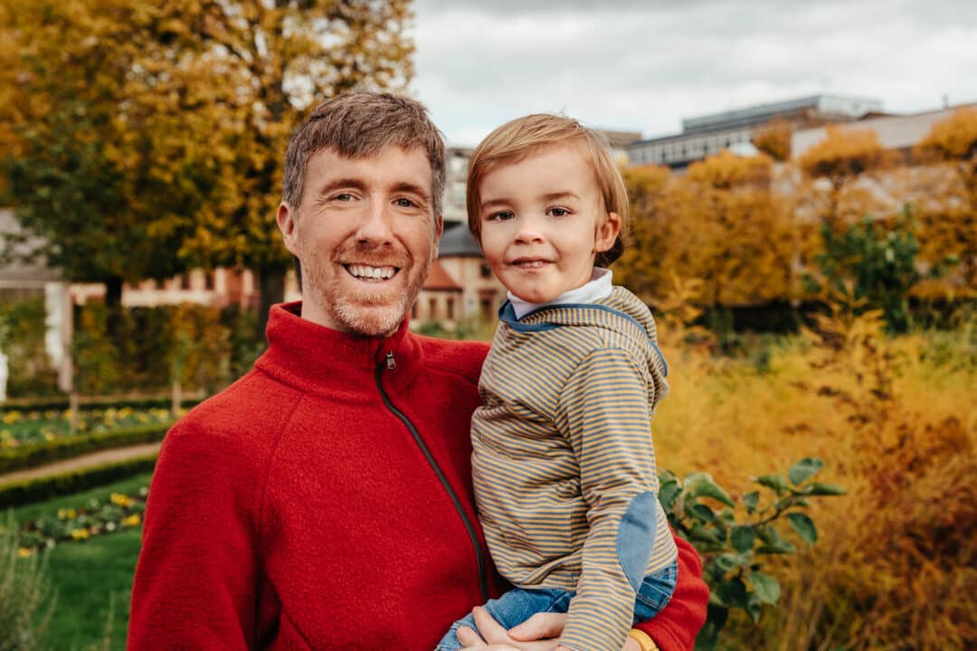 Ein Vater hat seinen Sohn auf dem Arm bei Familienfotos im Park