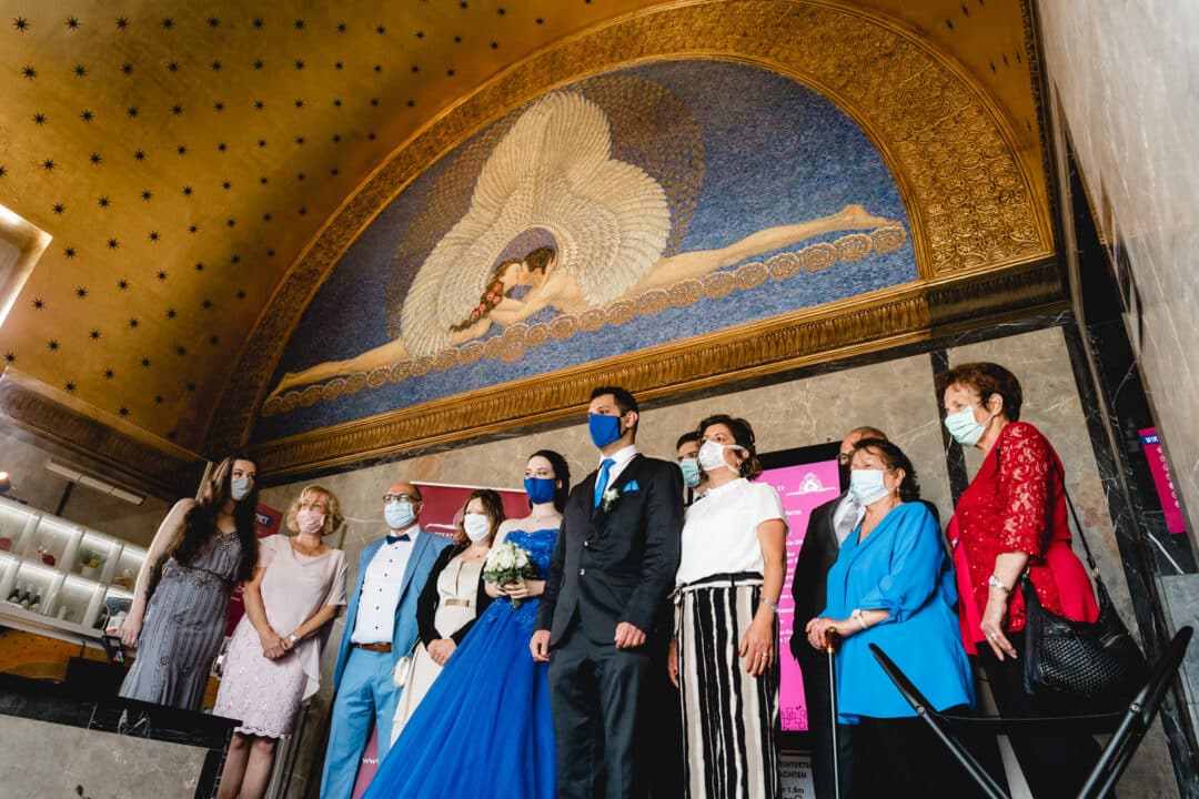 Hochzeitsgesellschaft steht im Eingangsbereich des Hochzeitsturms mit Gesichtsmasken