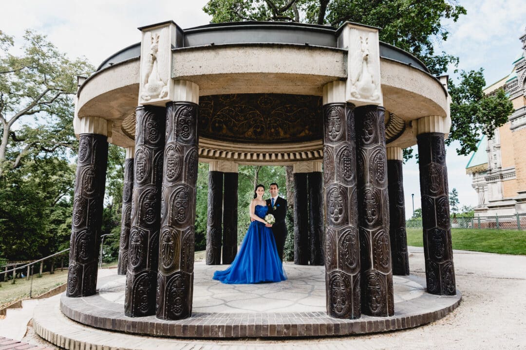Bräutigam und Bräutigam lachen in die Kamera und stehen unter einem Pavillion auf der Mathildenhöhe Darmstadt