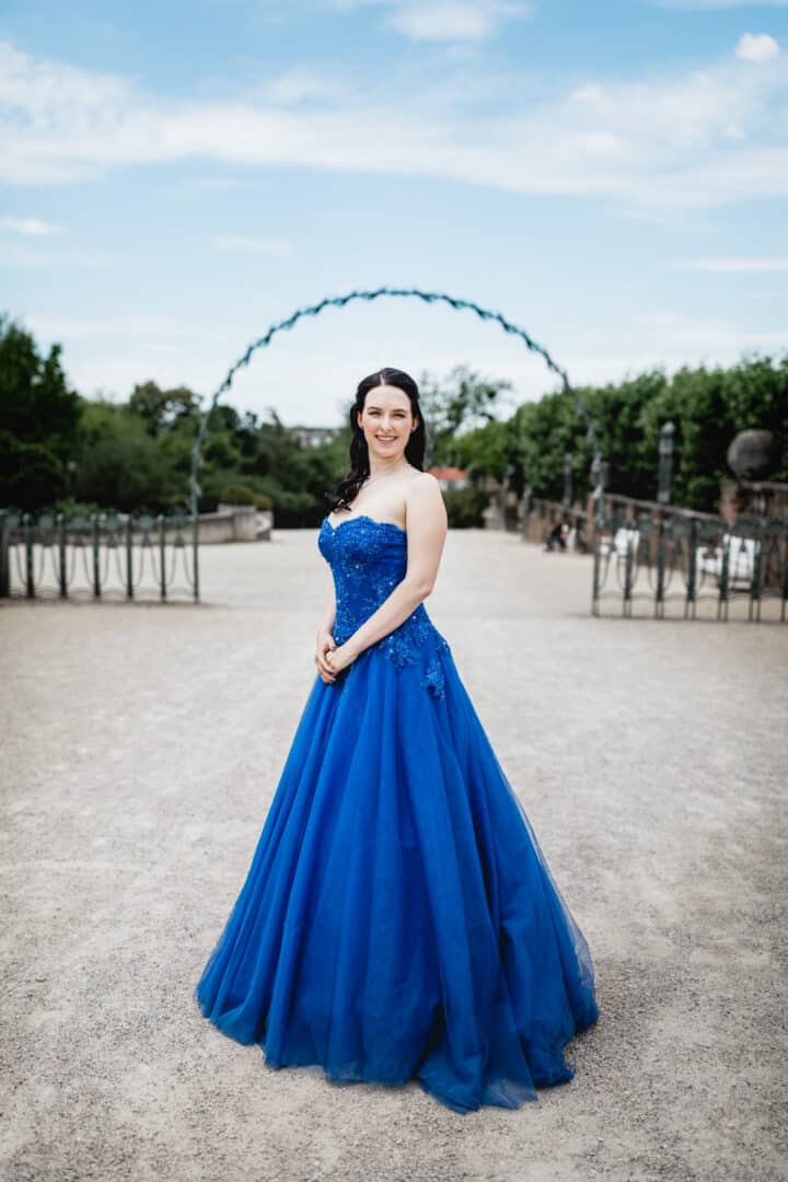 Braut im blauen Brautkleid auf der Mathildenhöhe Darmstadt steht unter Bogen