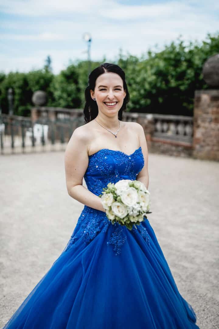 Braut im blauen Brautkleid auf der Mathildenhöhe Darmstadt lacht in die Kamera