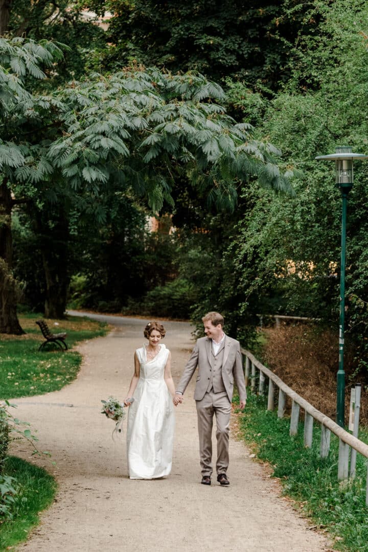 Brautpaar läuft Hand in Hand im Park des Prinz-Emil-Schlösschen in Darmstadt