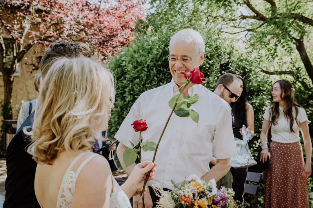 Ein Mann gratuliert mit Rosen dem Brautpaar nach der Trauung im Standesamt in Griesheim