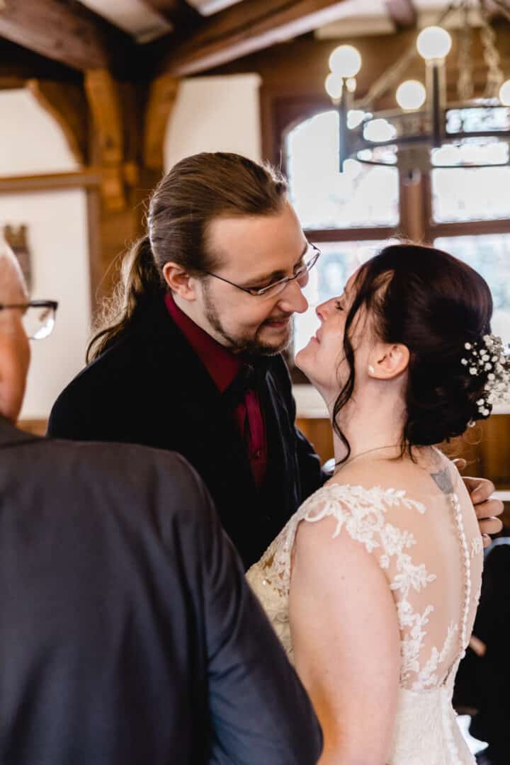 Bräutigam wartet auf Braut im Saal des Standesamt Gross-Gerau und küsst sie