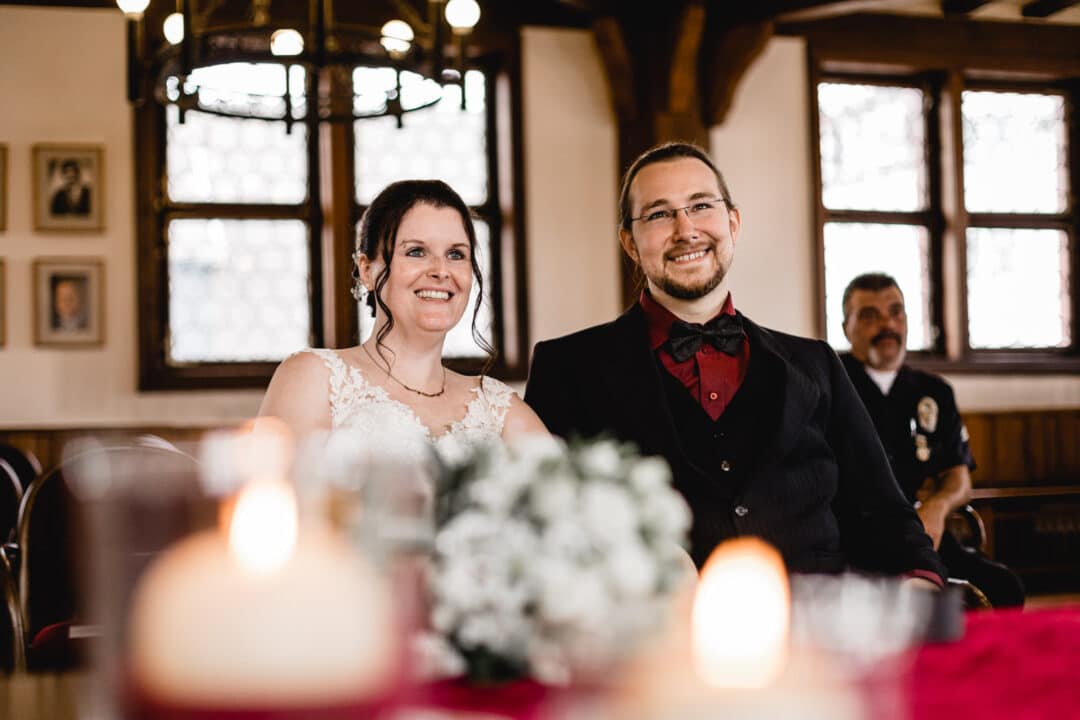 Braut und Bräutigam lachen die Standesbeamtin an während ihrer Trauung im alten Rathaus Gross-Gerau