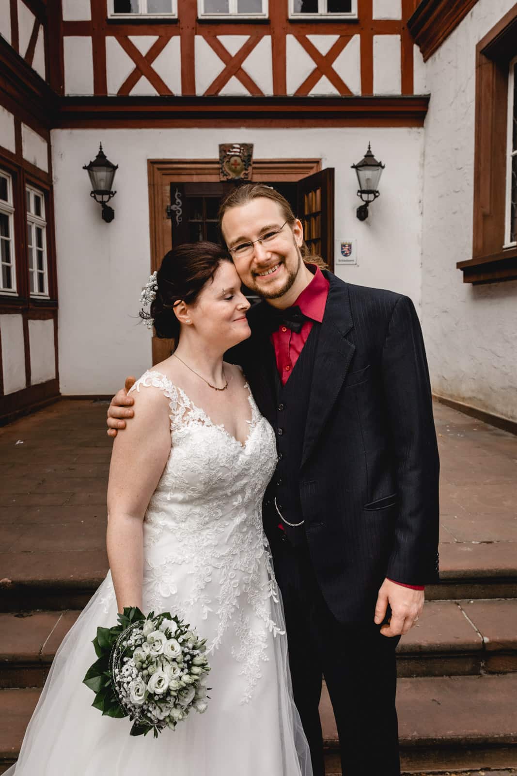 Brautpaar steht lachend vor dem Standesamt in Gross-Gerau und lacht