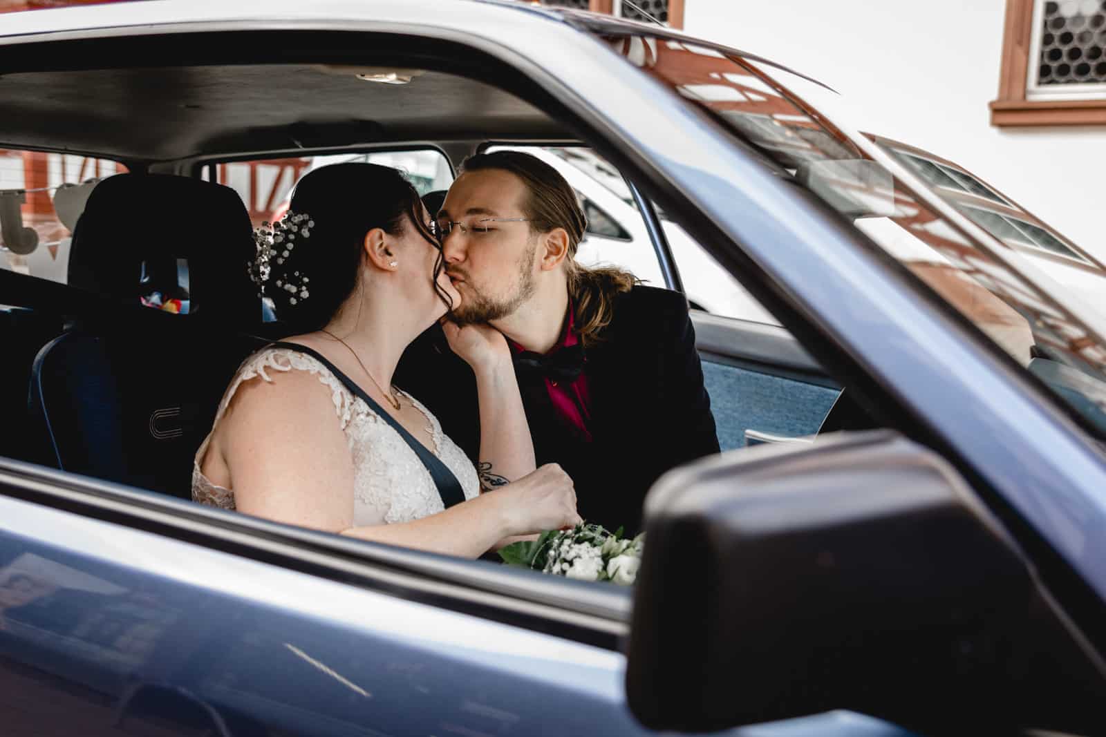 Brautpaar küsst sich im Auto vor dem Standesamt Gross-Gerau